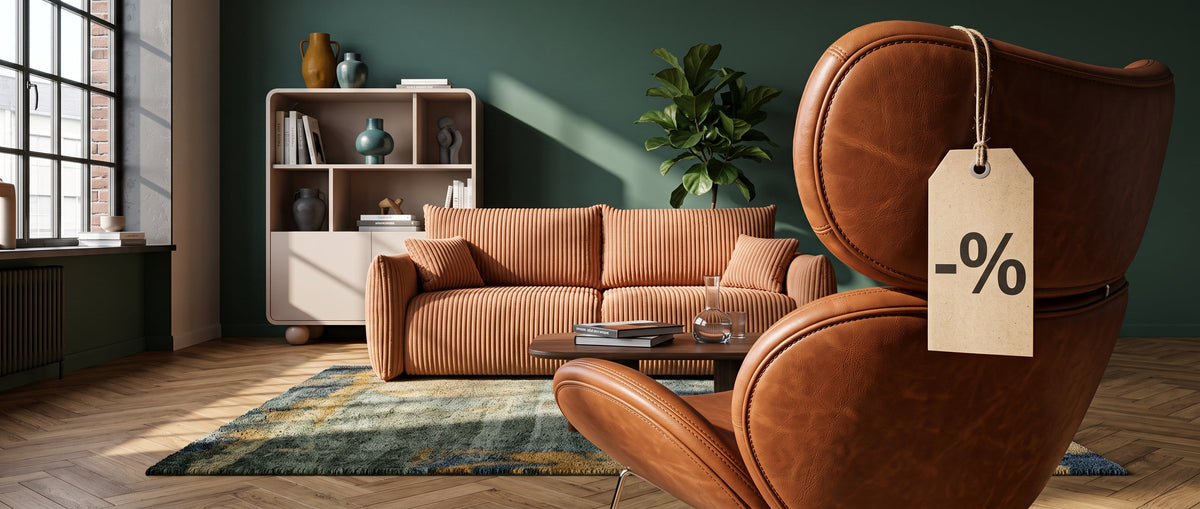 Living room with a caramel Alloro sofa, a leather Ferum armchair with a discount tag and a Ballo bookcase against a dark green wall