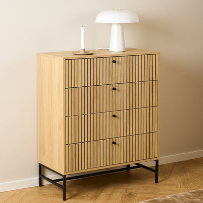 Commode Bambouz 81 x 100 devant un mur beige, avec une lampe blanche et une bougie sur un parquet à motif en chevrons – commode pour chambre à coucher
