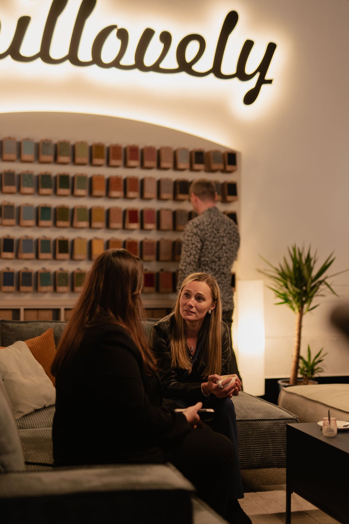 Femmes discutant assises sur le canapé d’angle May dans le showroom Pillovely