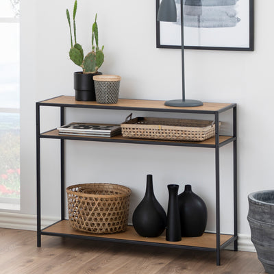 Console Skeleto 100 x 79 « Chêne sauvage » placée contre un mur, avec un cactus, une lampe, des paniers et des vases noirs sur l'étagère du bas