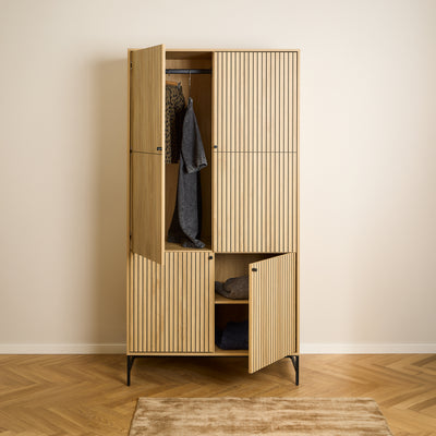 Bambouz-kast 99x200 op een vloer met visgraatpatroon – open deuren, kleding aan de stang en truien op de plank, kast voor de slaapkamer